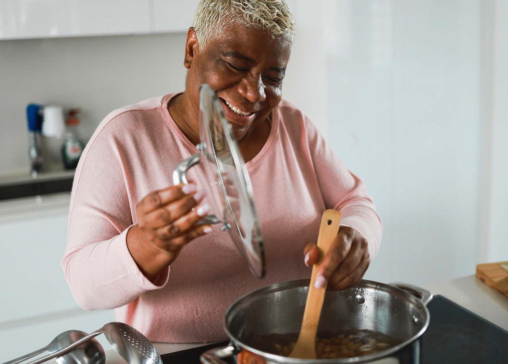 elderly woman stirring a pot in the kitchen