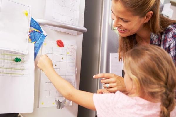 Mother and daughter using chore chart
